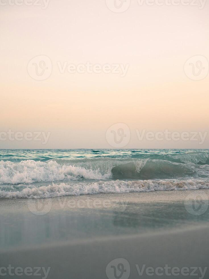 a person standing on the beach with a surfboard photo