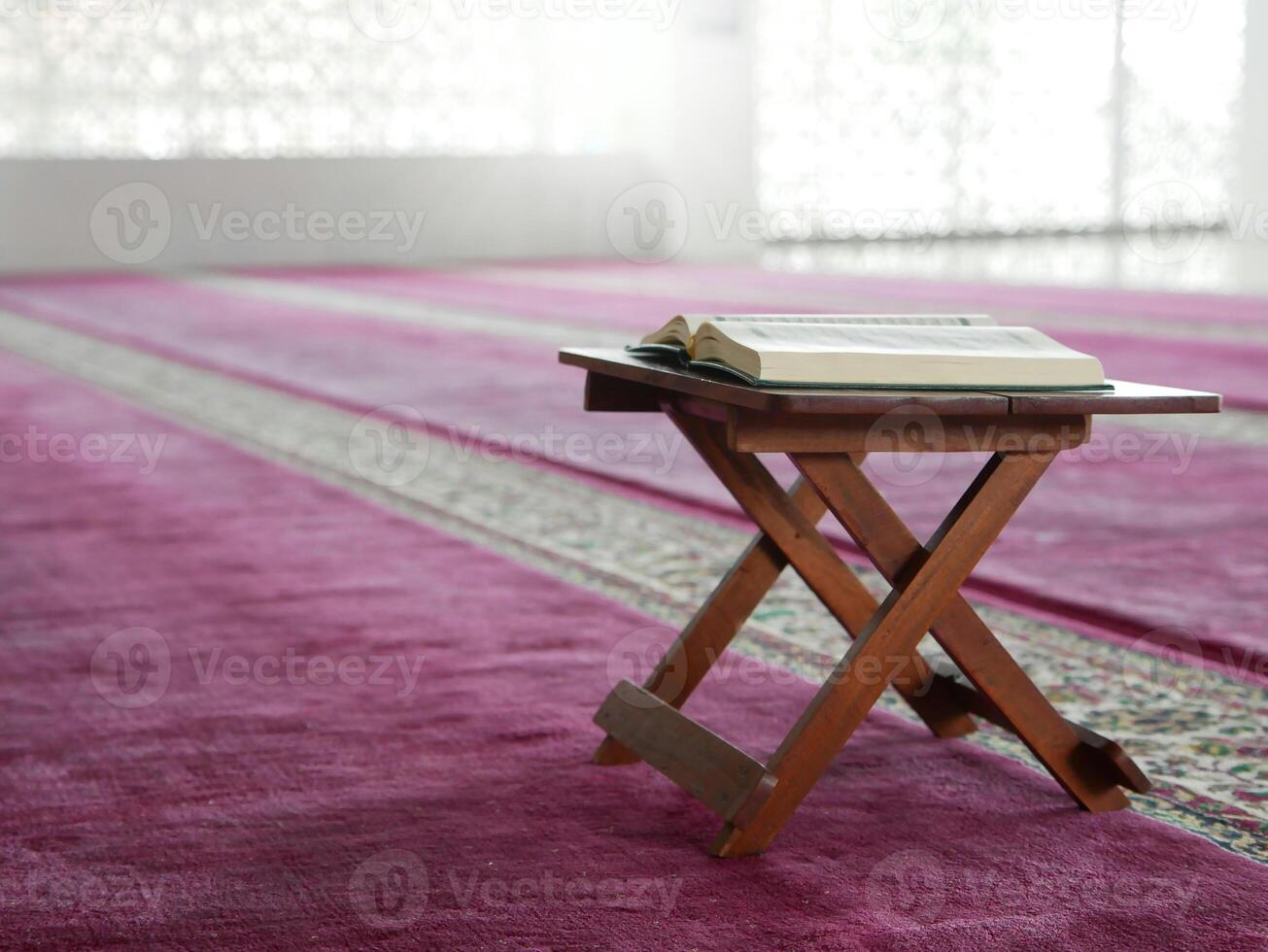 open book on a wooden table in a mosque photo