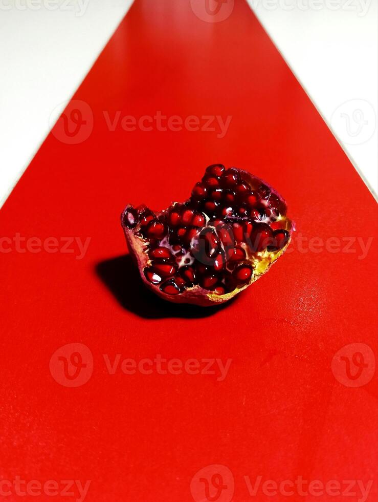 a pomegranate on a red table photo