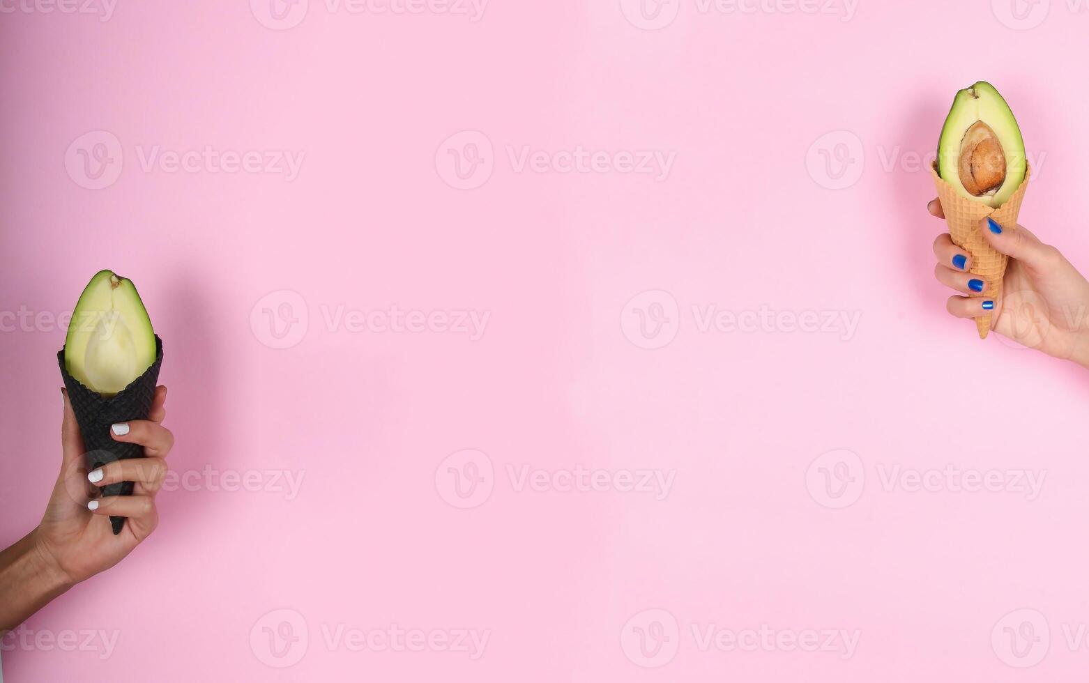 two hands holding up two ice cream cones with an avocado in the middle photo