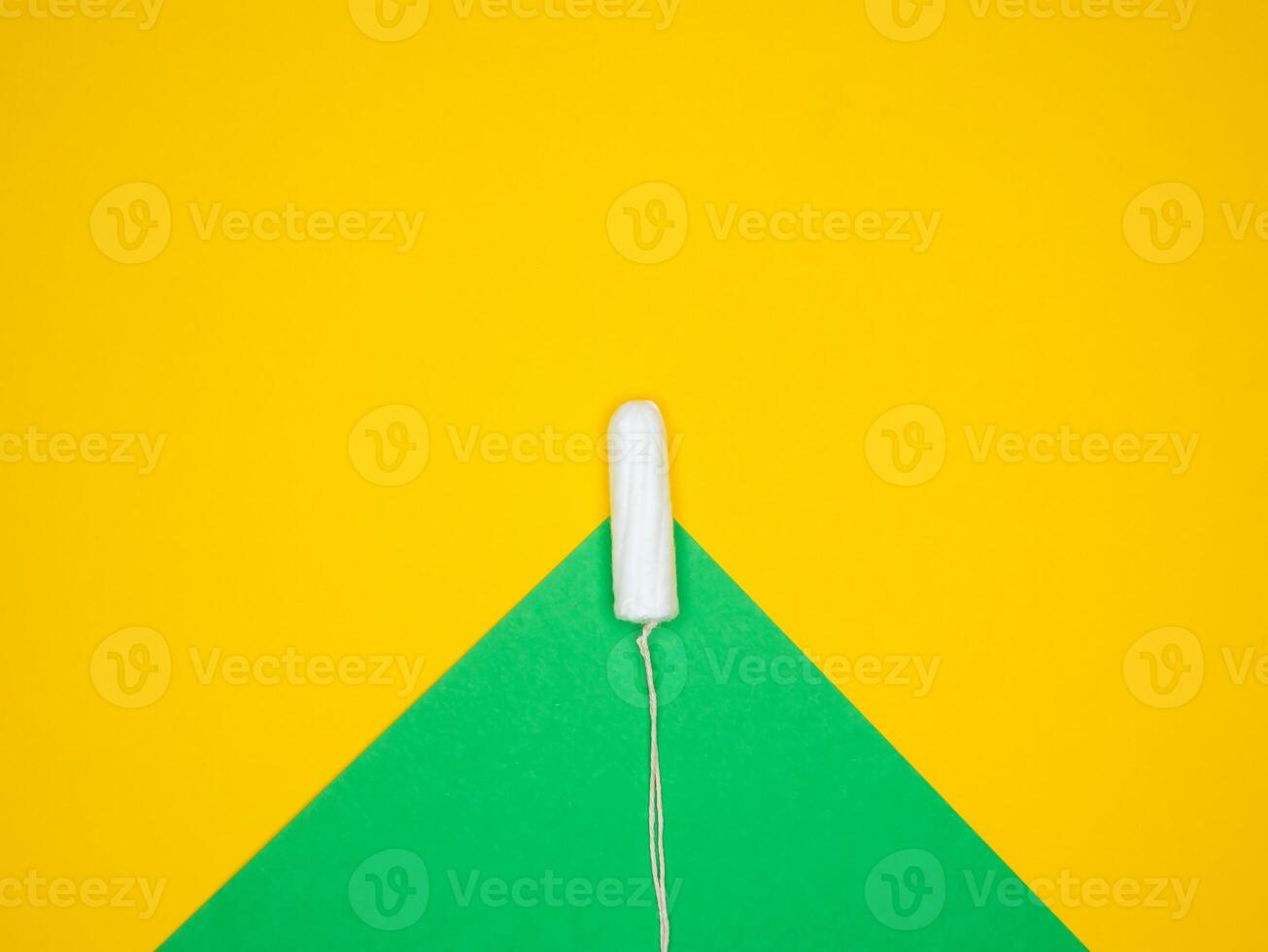 a white toothbrush is sitting on top of a green and yellow triangle photo