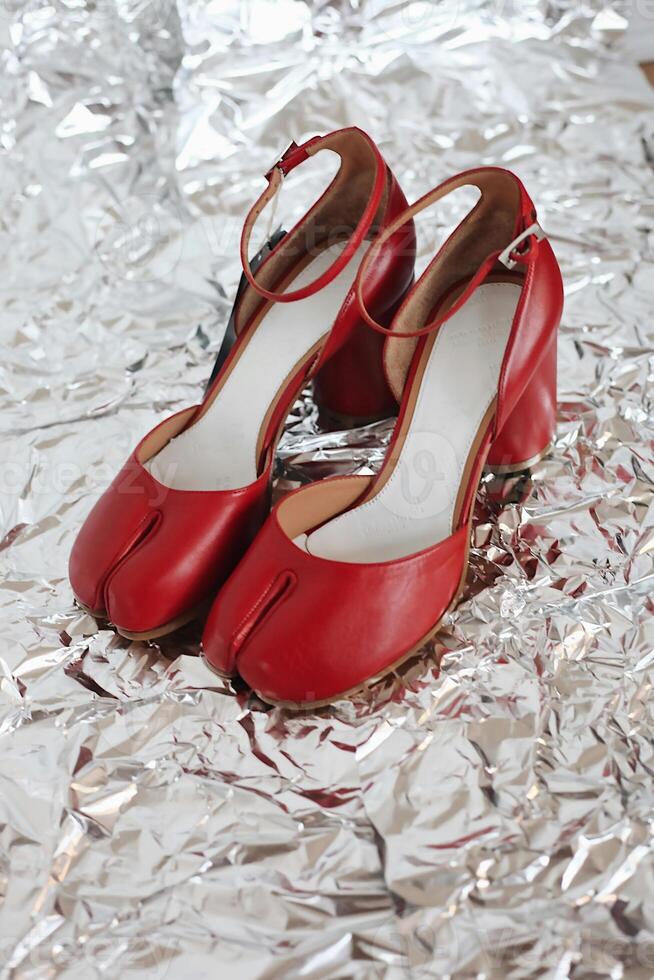 a pair of red shoes on a silver surface photo