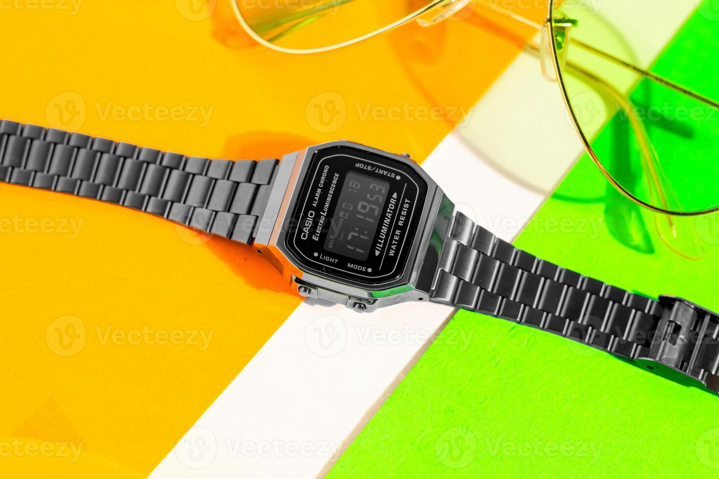 a black watch and sunglasses on a colorful surface photo