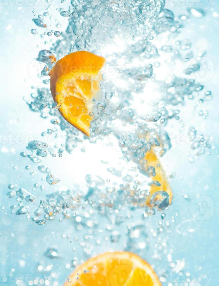 a slice of orange is being splashed in water photo