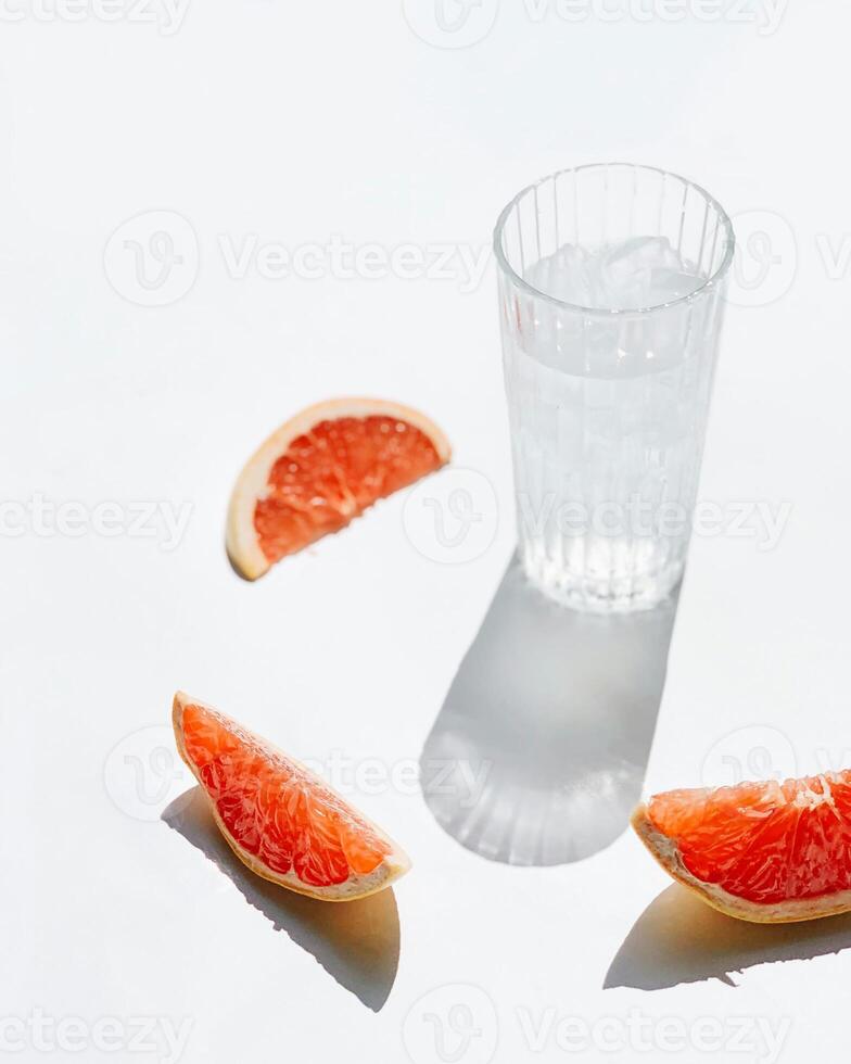 a glass of water and a slice of grapefruit photo