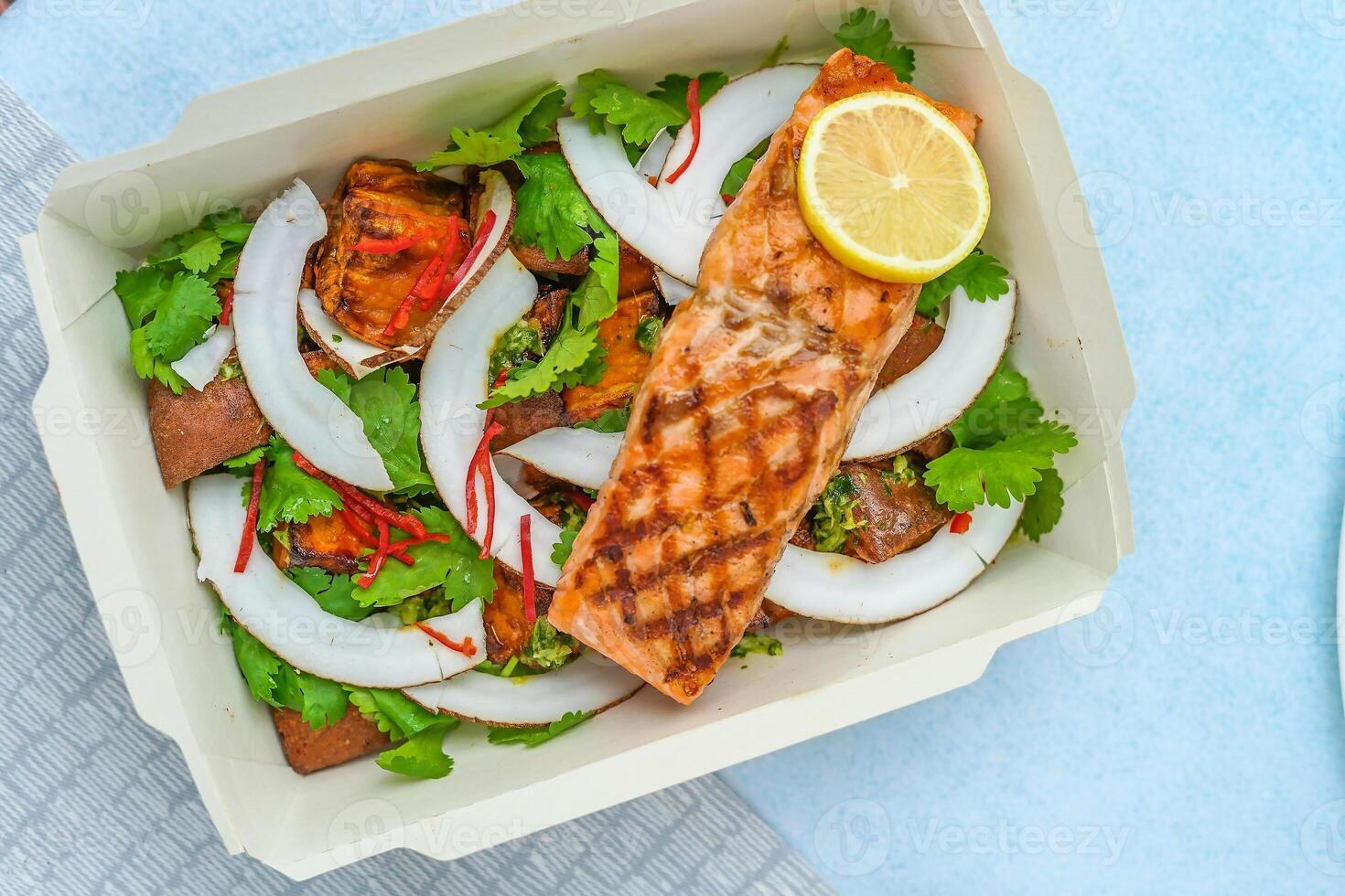salmon and vegetables in a box on a table photo