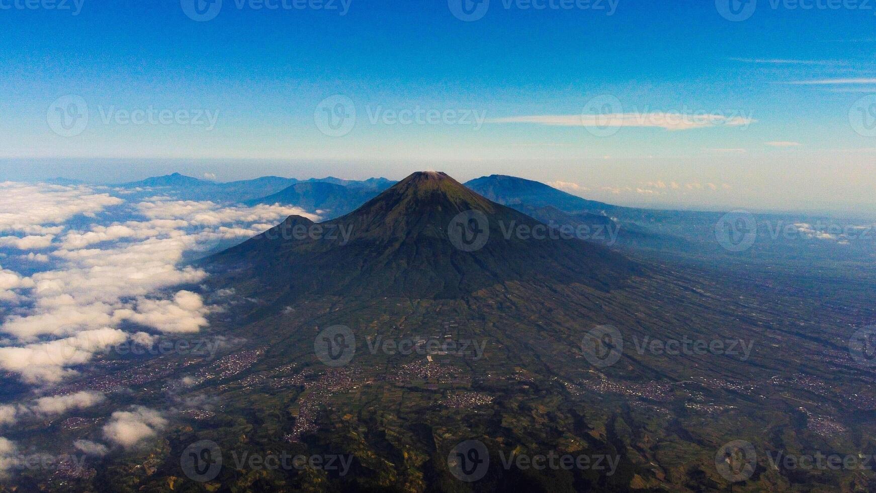 From the summit of Mount Prau, breathtaking views of three towering peaks unfold. A favorite among hikers, this stunning landscape showcases Indonesia's natural beauty and adventure. photo