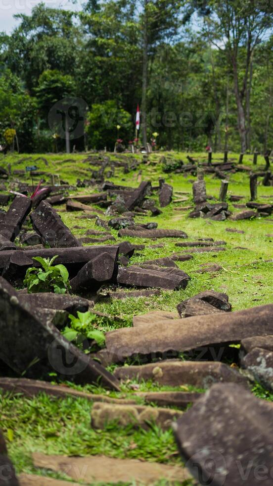 Gunung Padang, also known as Pyramid Mountain, stands in West Java, Indonesia. This historical site, surrounded by dense green vegetation photo