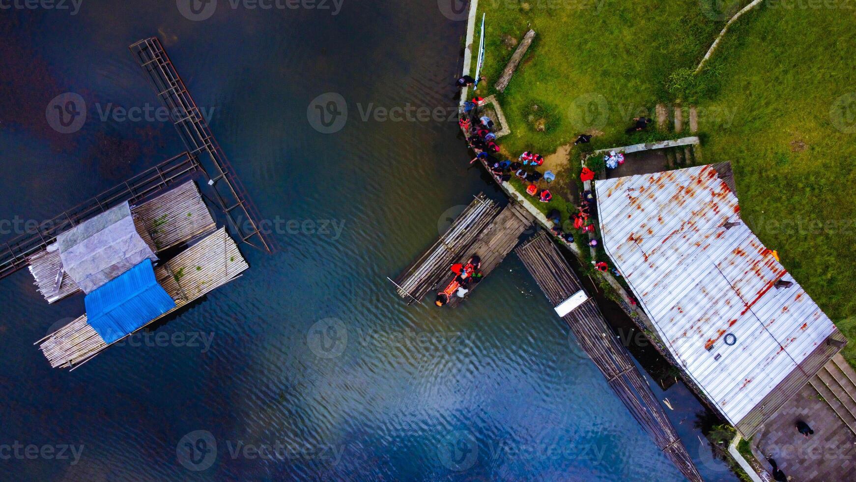 Aerial view of a stunning lake in Bali, a perfect tourist spot where visitors enjoy the serene waters, surrounded by vibrant green nature and tranquil landscapes. photo
