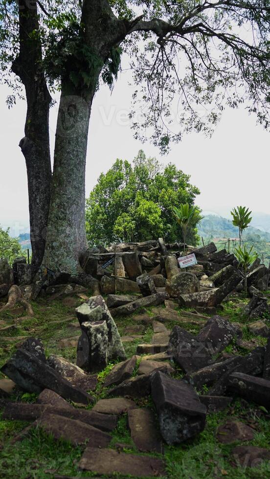 Gunung Padang, also known as Pyramid Mountain, stands in West Java, Indonesia. This historical site, surrounded by dense green vegetation photo
