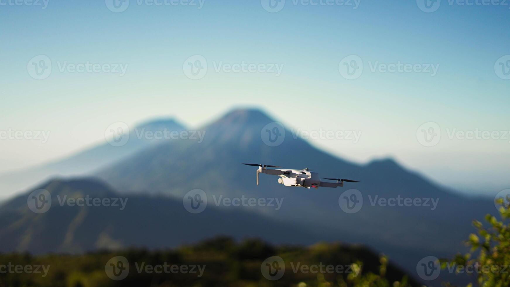 A breathtaking view from Mount Prau reveals three towering mountains, captured by an aerial camera. photo