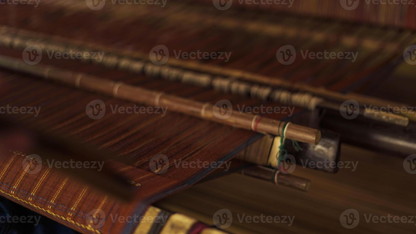 A Baduy woman weaves in front of her home using traditional tools. Her skilled hands create beautiful patterns, preserving cultural heritage and artistry. photo