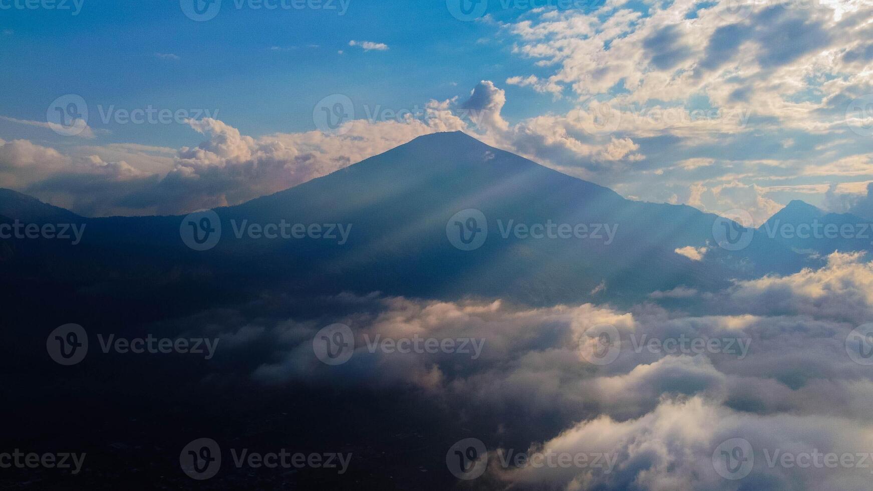 Experience breathtaking aerial views of the rolling hills in Sembalun, at the foot of Mount Rinjani, with expansive savanna turning golden at sunrise. photo