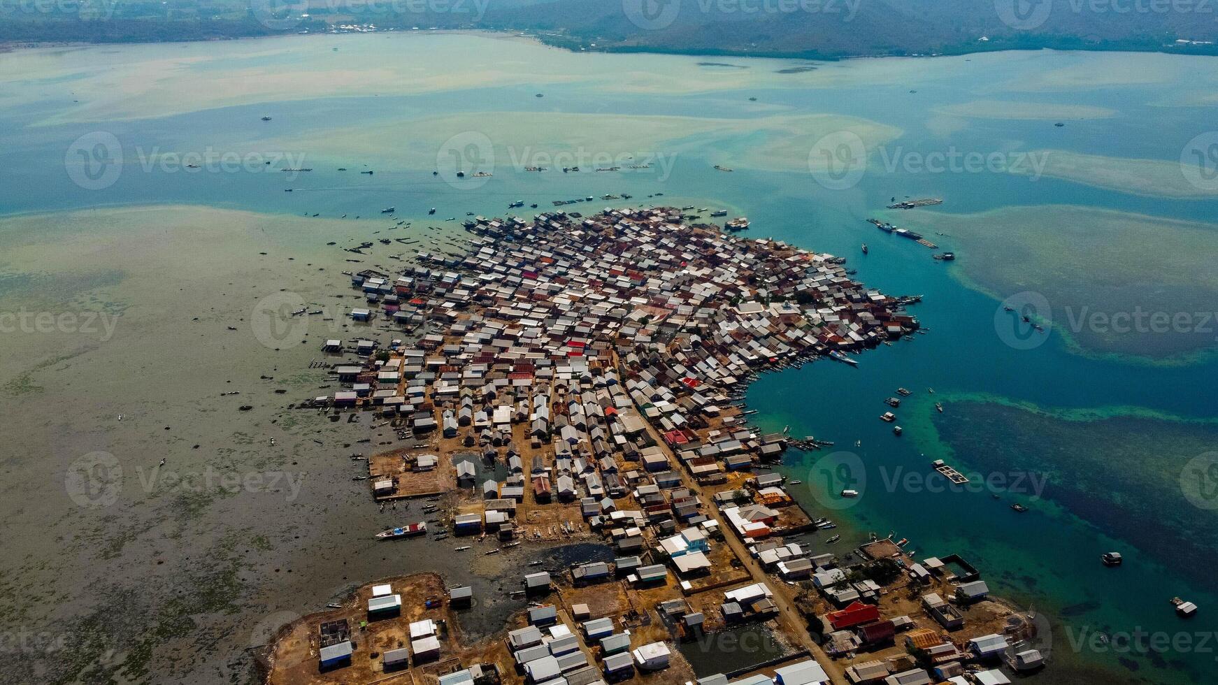 Explore stunning aerial footage of the world's most unique at Bungin Island, densely populated island, nestled in vibrant blue waters with 3,000 residents in Nusa Tenggara Barat, Indonesia photo