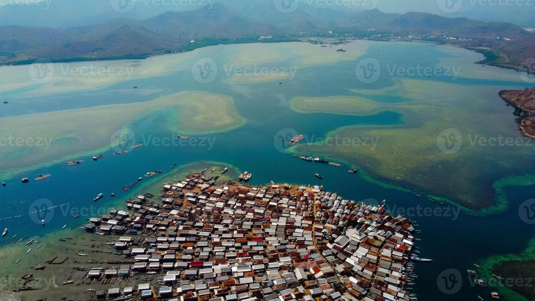 Explore stunning aerial footage of the world's most unique at Bungin Island, densely populated island, nestled in vibrant blue waters with 3,000 residents in Nusa Tenggara Barat, Indonesia photo
