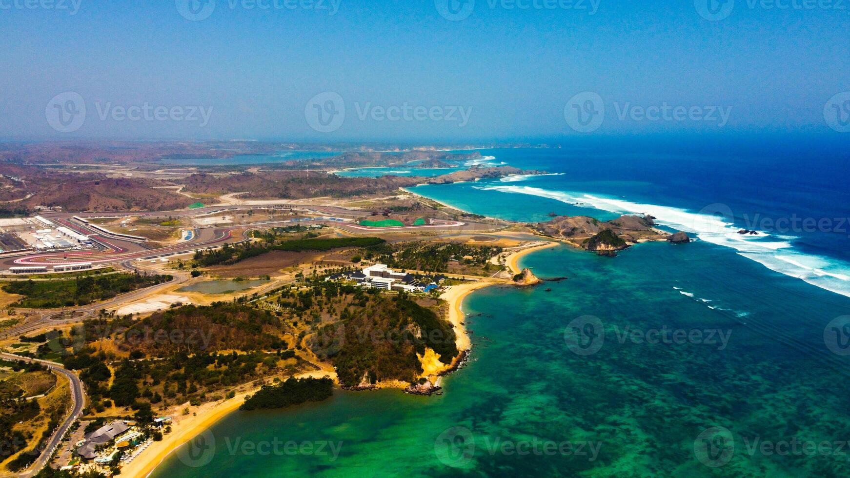 Experience stunning aerial views of hills behind the Mandalika circuit in Lombok, with a breathtaking sunset atmosphere as the camera glides through the clouds. photo