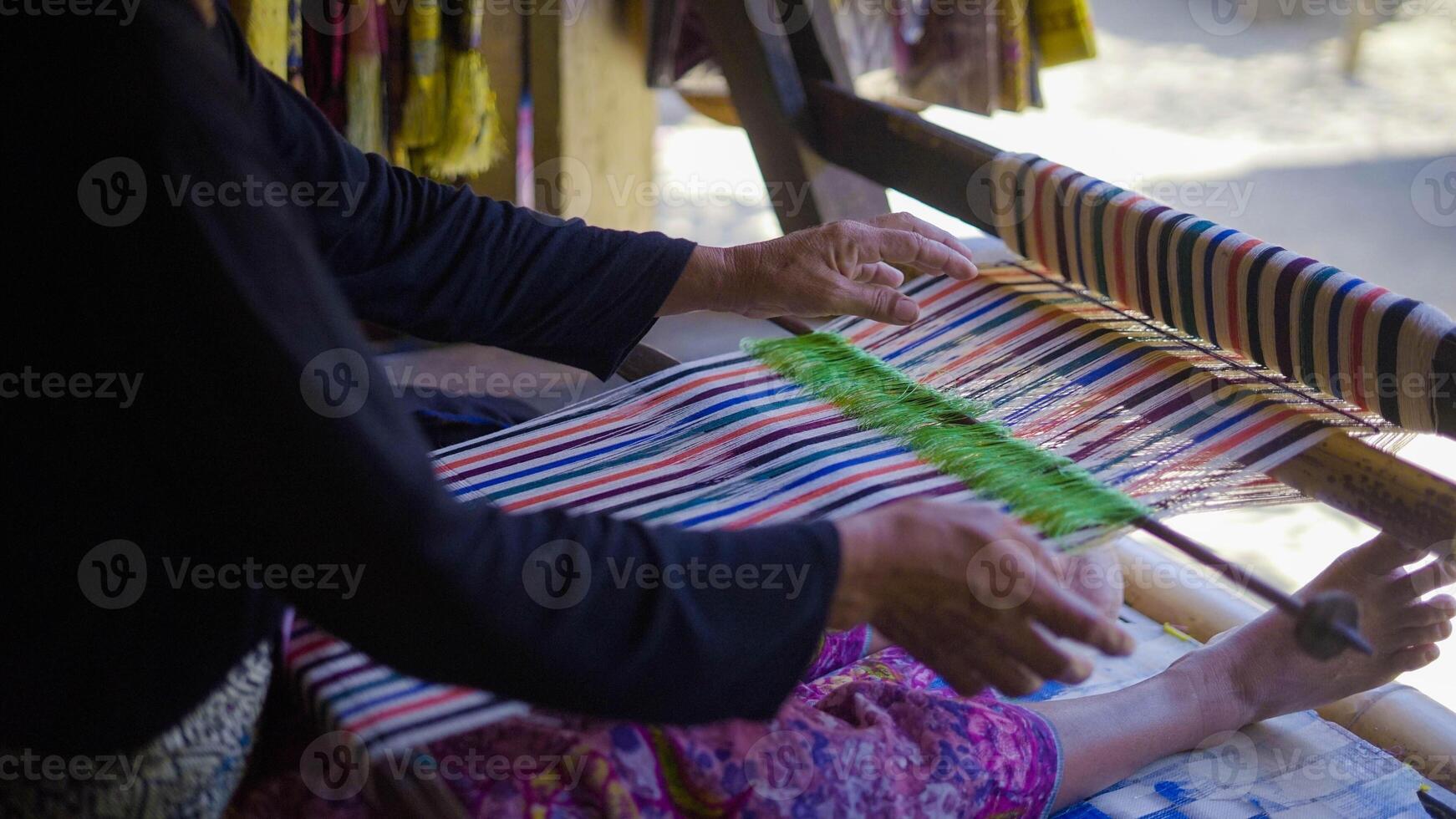 Colorful of Kain Tenun, an Indonesian traditional hand woven fabric from West Nusa Tenggara or Lombok, hanging for sale in Sade village as souvenirs photo