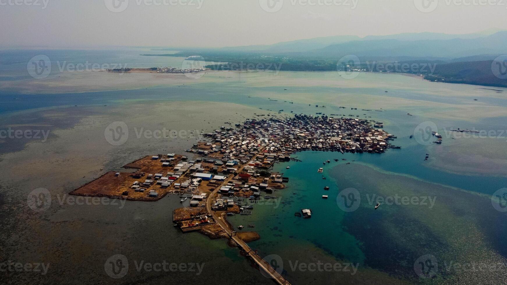 Explore stunning aerial footage of the world's most unique at Bungin Island, densely populated island, nestled in vibrant blue waters with 3,000 residents in Nusa Tenggara Barat, Indonesia photo