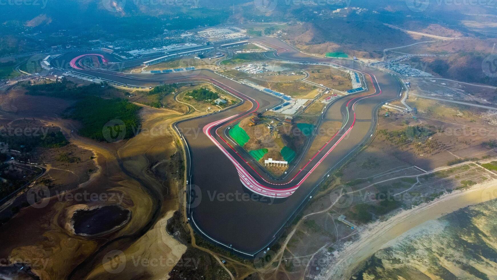 Experience stunning aerial views of hills behind the Mandalika circuit in Lombok, with a breathtaking sunset atmosphere as the camera glides through the clouds. photo
