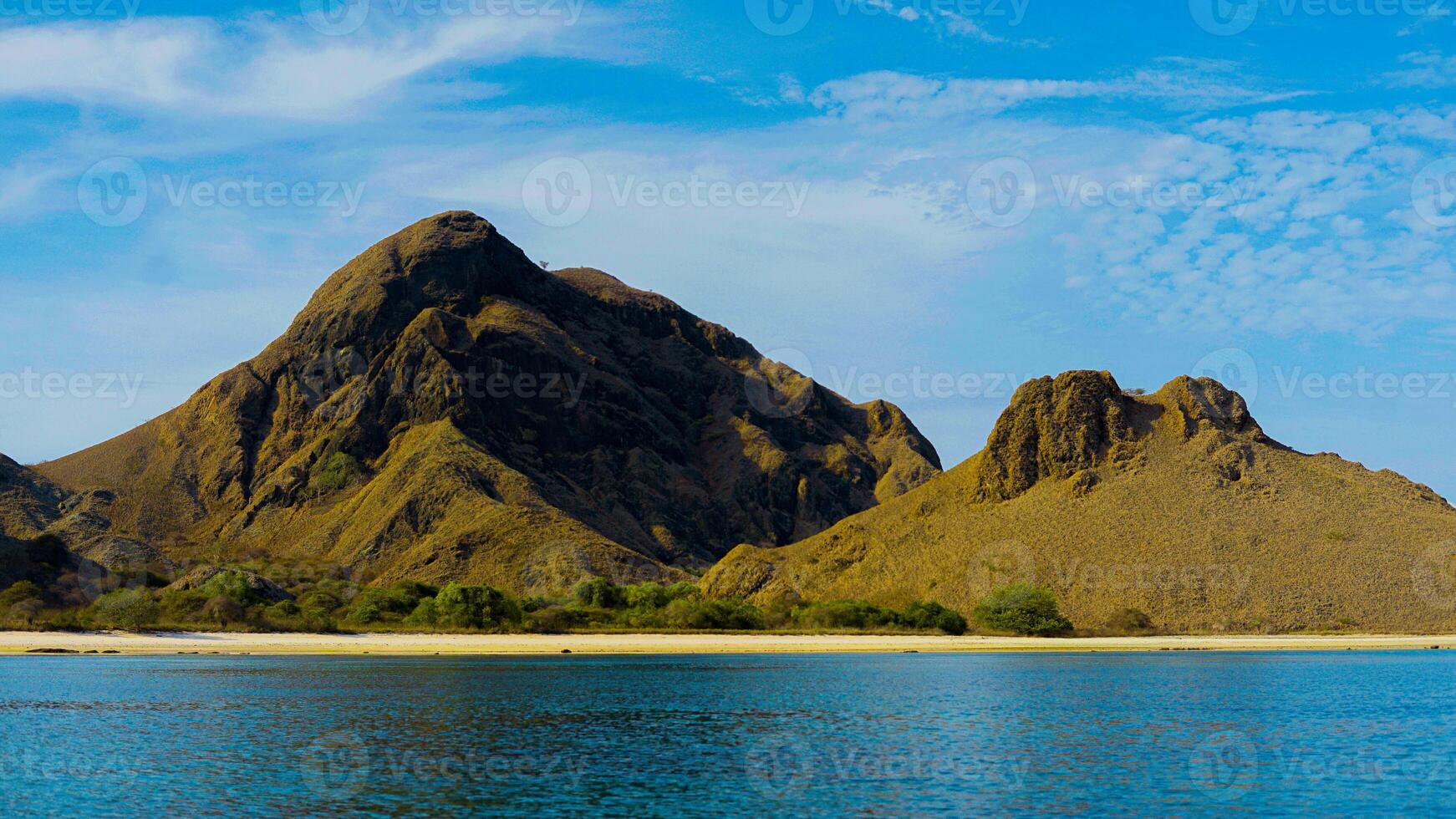 On Padar Island, Pink Beach boasts pristine pink sands and vibrant blue waters, under a clear sky, offering a serene escape with no other visitors. photo