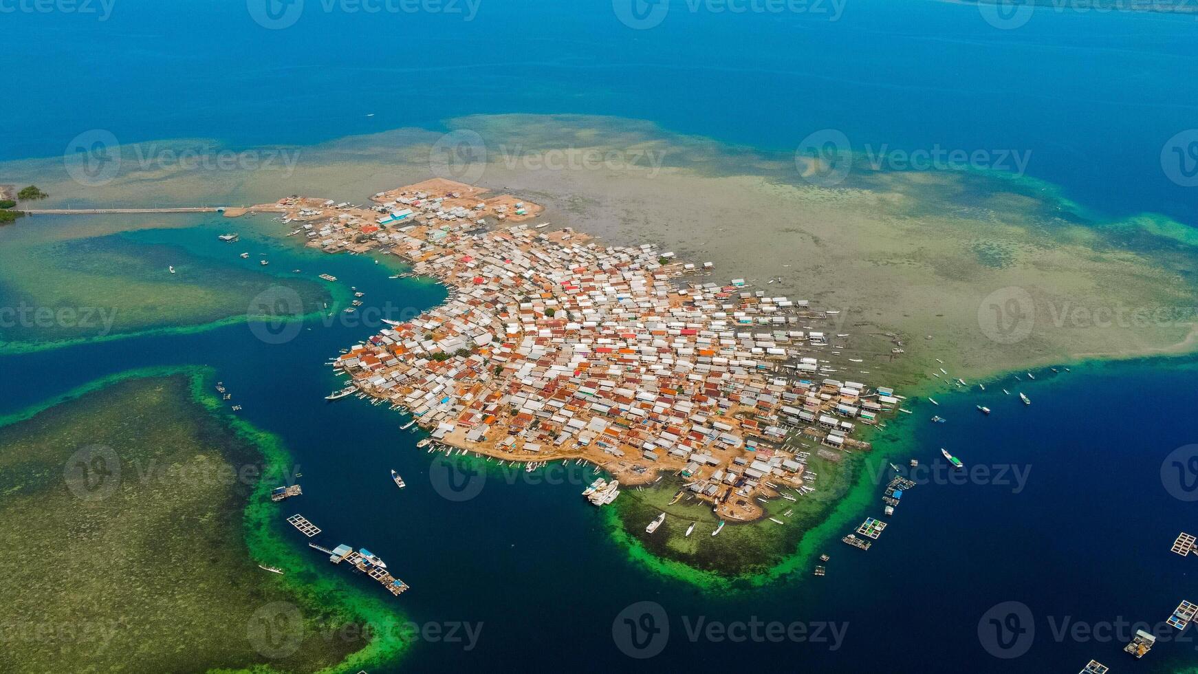 Explore stunning aerial footage of the world's most unique at Bungin Island, densely populated island, nestled in vibrant blue waters with 3,000 residents in Nusa Tenggara Barat, Indonesia photo