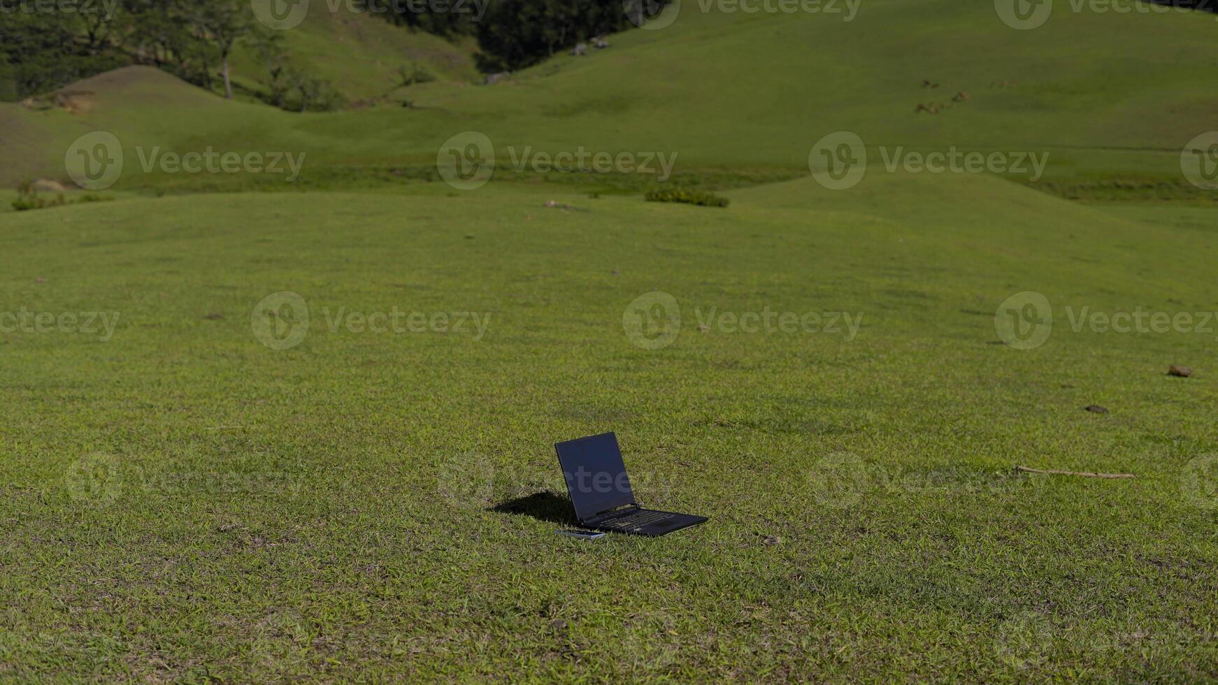 Laptop outside concept. Empty copy space, blank screen mockup. Soft focus laptop in nature background. Ecology travel and work outside office concept. photo
