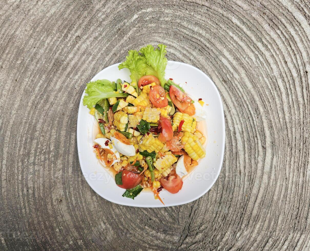 Spicy corn salad with salted egg. Thai call Tam Khao Pod Kai Kem. high angle view photo