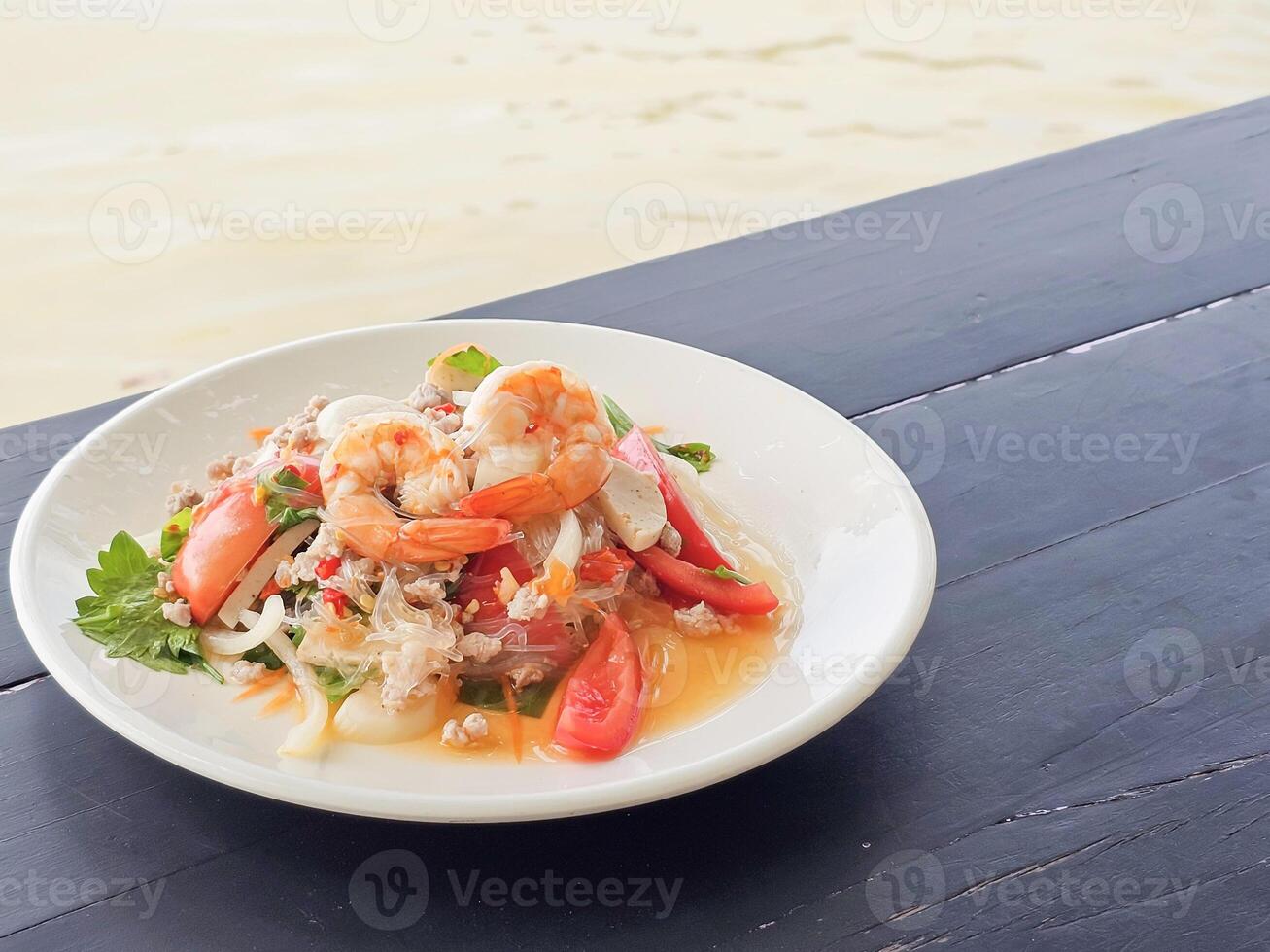 Spicy Glass Noodle Salad, mixed shrimp with minced pork, Thai call Yum Woon Sen on the table. Side view with copy space photo