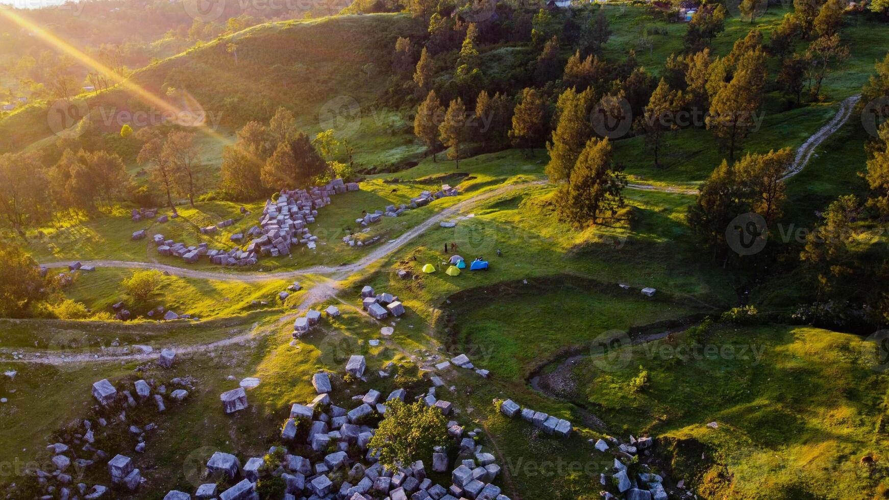 Explore the stunning marble rocks of NTT, where majestic formations meet lush green grasslands. Witness the beauty of cows grazing peacefully in the morning light, photo