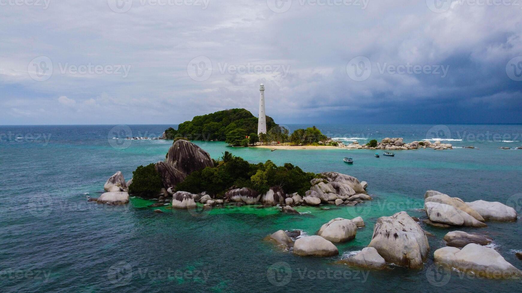Aerial View of Light House at Lengkuas Island of Belitung Indonesia. Dramatic Tropical island with White Sandy beach and Trees. POI Point of Interest Drone Shot. Bird Eye View photo