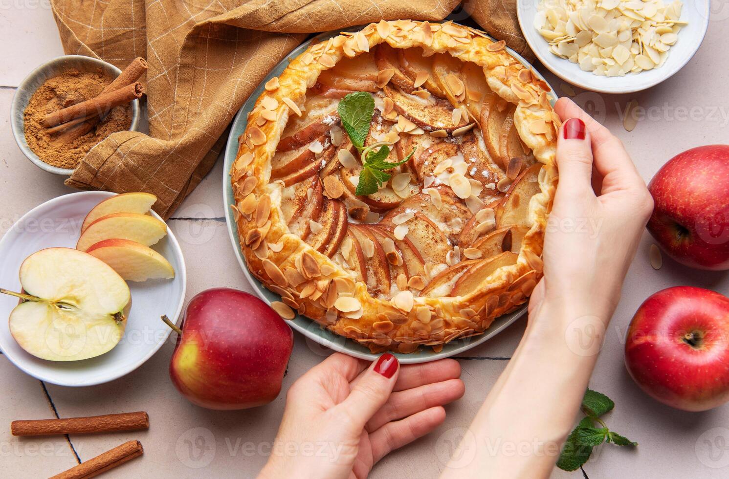 Apple galette preparation with fresh ingredients and spices on a kitchen countertop photo