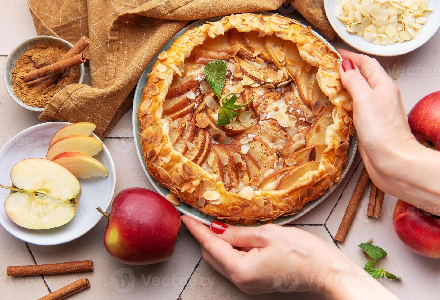 Apple galette preparation with fresh ingredients and spices on a kitchen countertop photo
