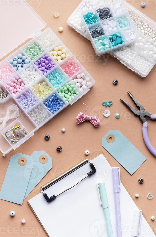 Crafting supplies arranged on a workspace with beads, tools, tags for personalized jewelry making photo