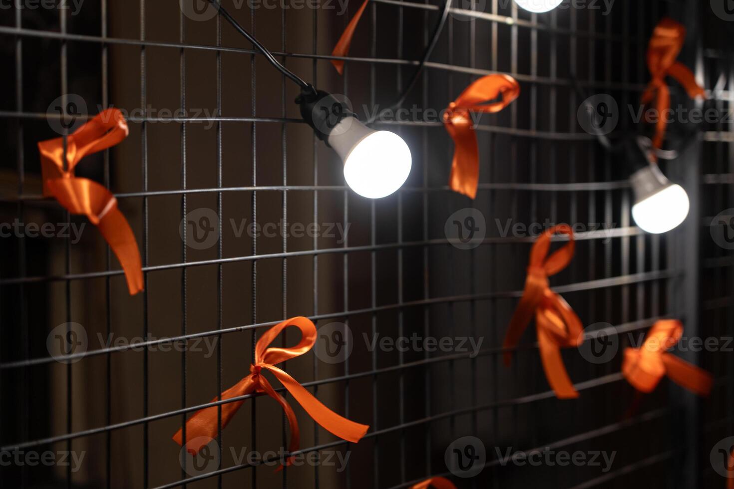 Garland on an iron fence with ribbon bows at night. New Year's mood. photo