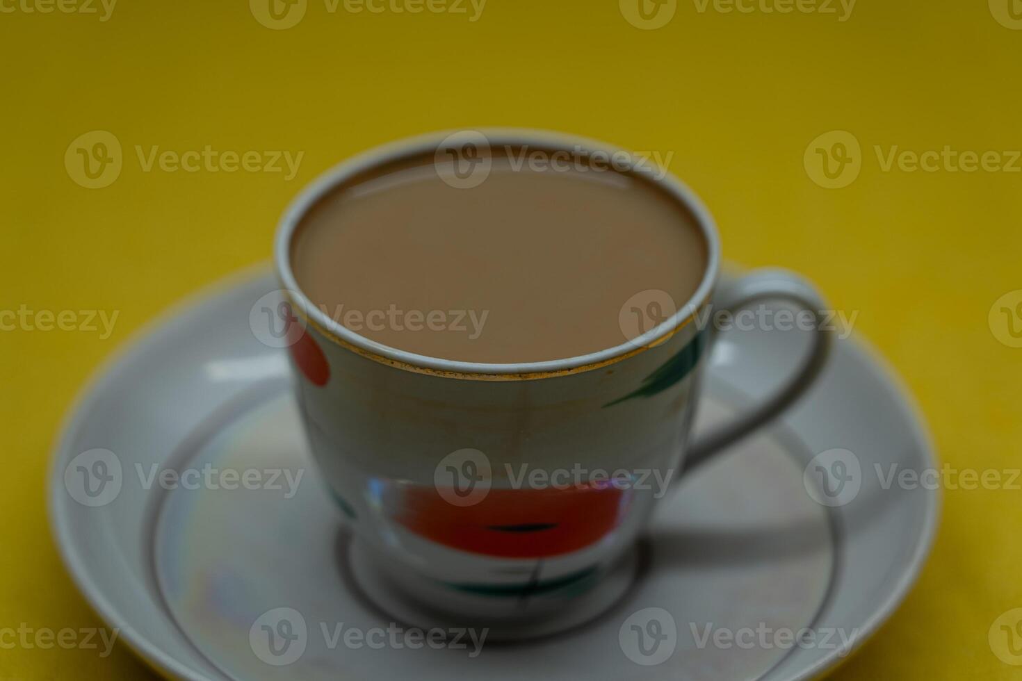 A mug of coffee with milk. Mug in a saucer on a yellow background. Top-down view photo