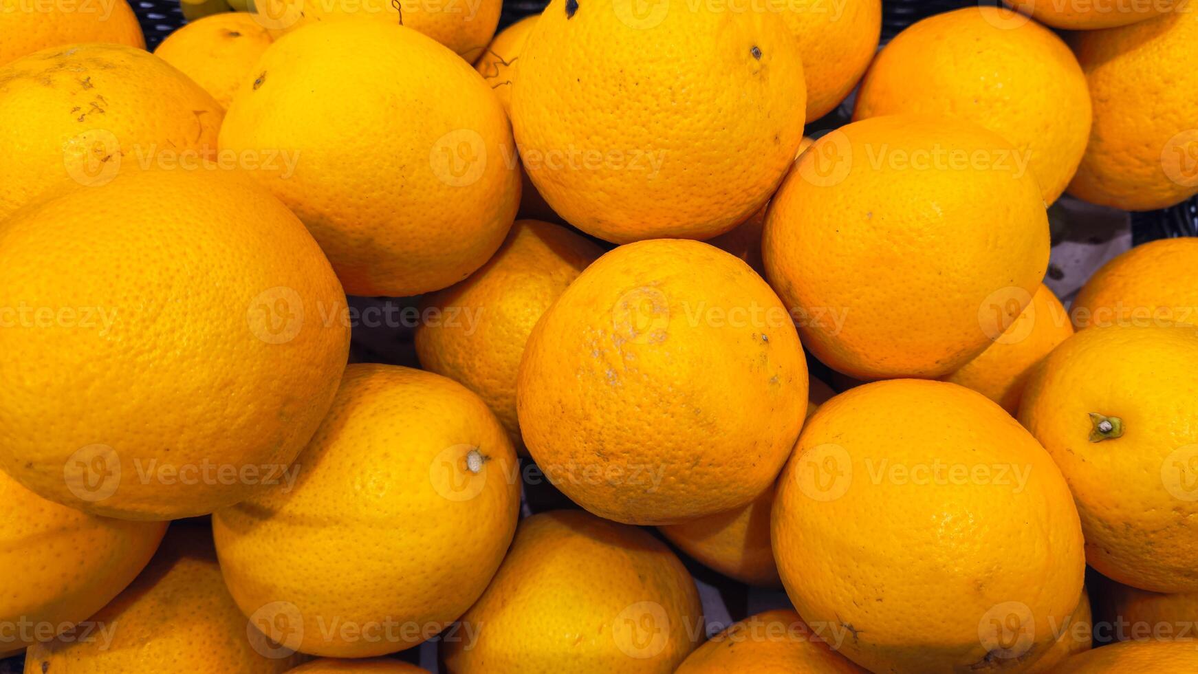 An orange on the counter at the market. The background is oranges. Oranges photo