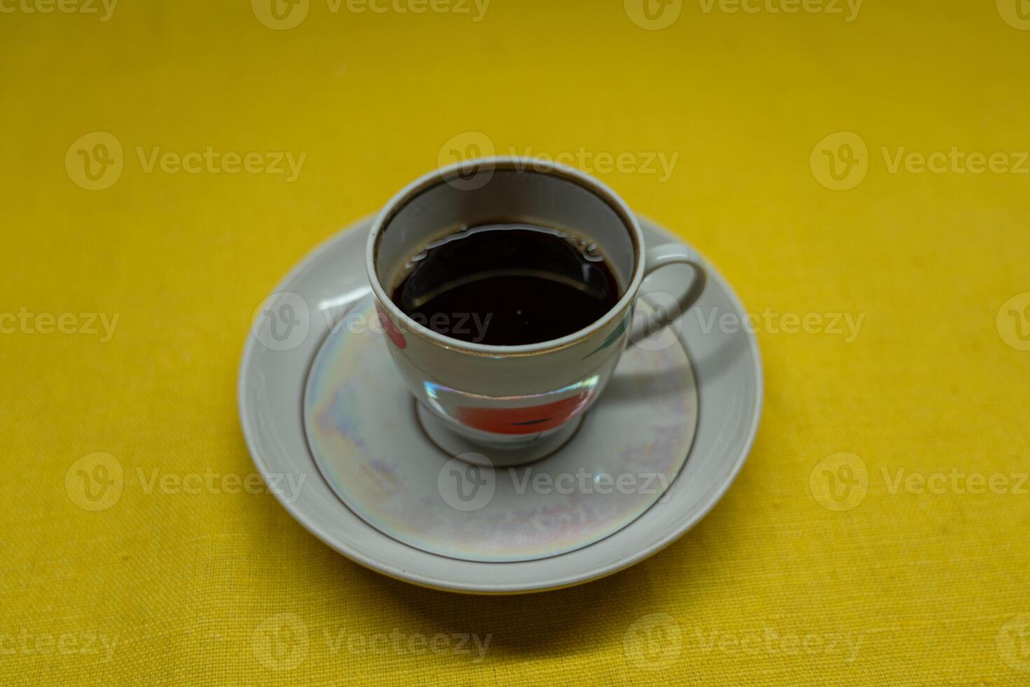 Instant coffee in a mug. A mug in a saucer on a yellow background. Top-down view photo