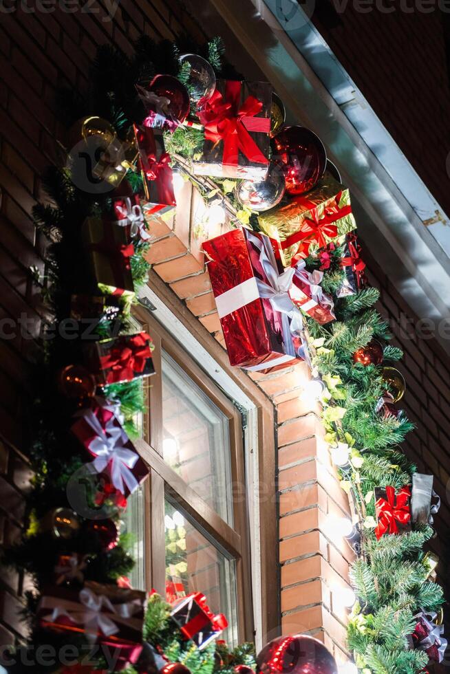 Christmas tree toys and fir branches decorate the window at night. New Year mood photo