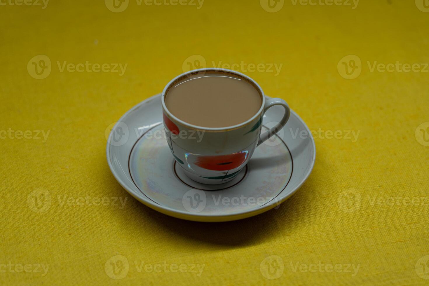 A mug of coffee with milk. Mug in a saucer on a yellow background. Top-down view photo