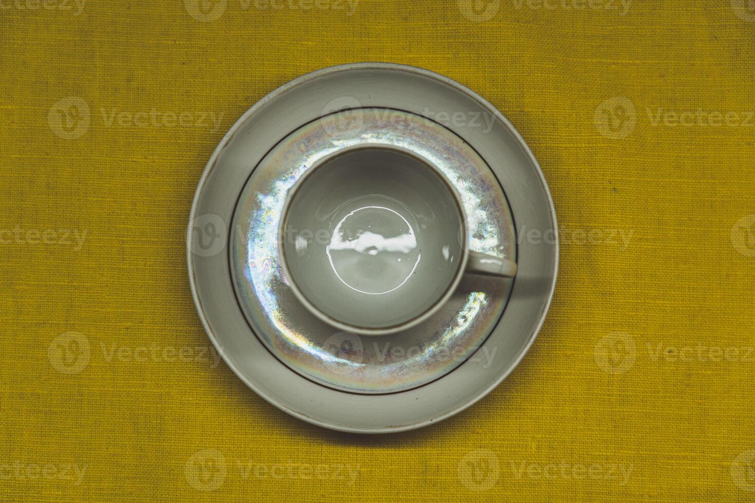 A cup in a saucer on a yellow background, top view. A coffee mug. Espresso Mug photo