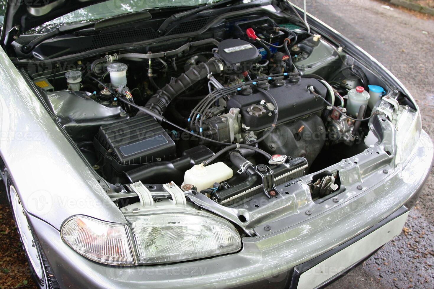 view of a car with its hood open, showcasing the engine and various mechanical parts. Ideal for automotive and mechanical themes, depicting technology, repair, and engineering concepts. photo