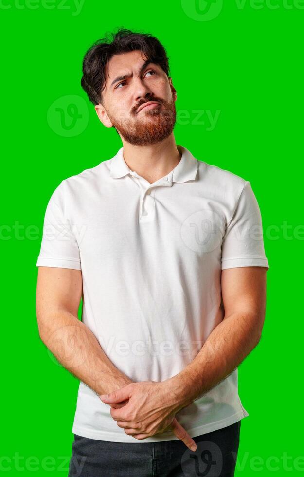 A man contemplates thoughtfully against a bright green background photo