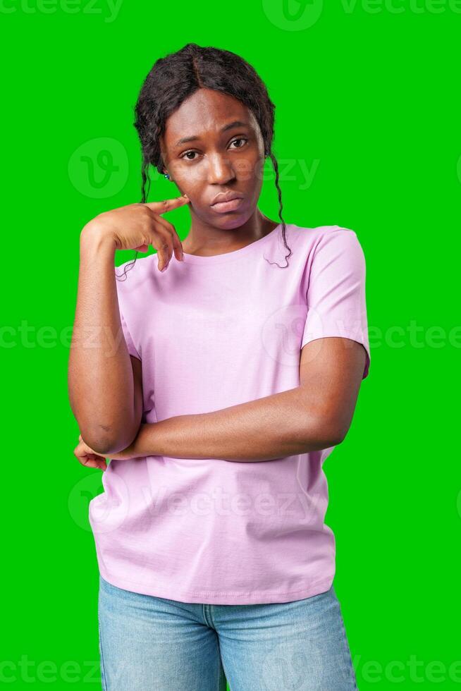 Thoughtful woman pondering in front of a bright green background during a casual moment photo