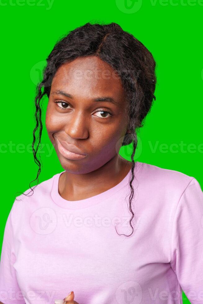 Young woman with curly hair shows a skeptical expression against a bright green background photo