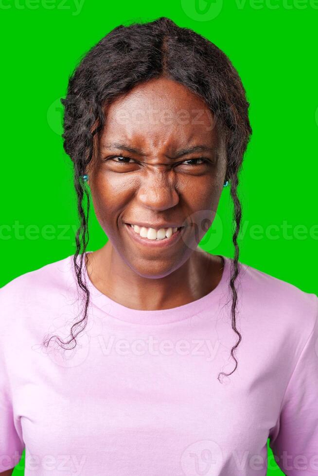 Happy young woman making a playful face against a bright green backdrop photo