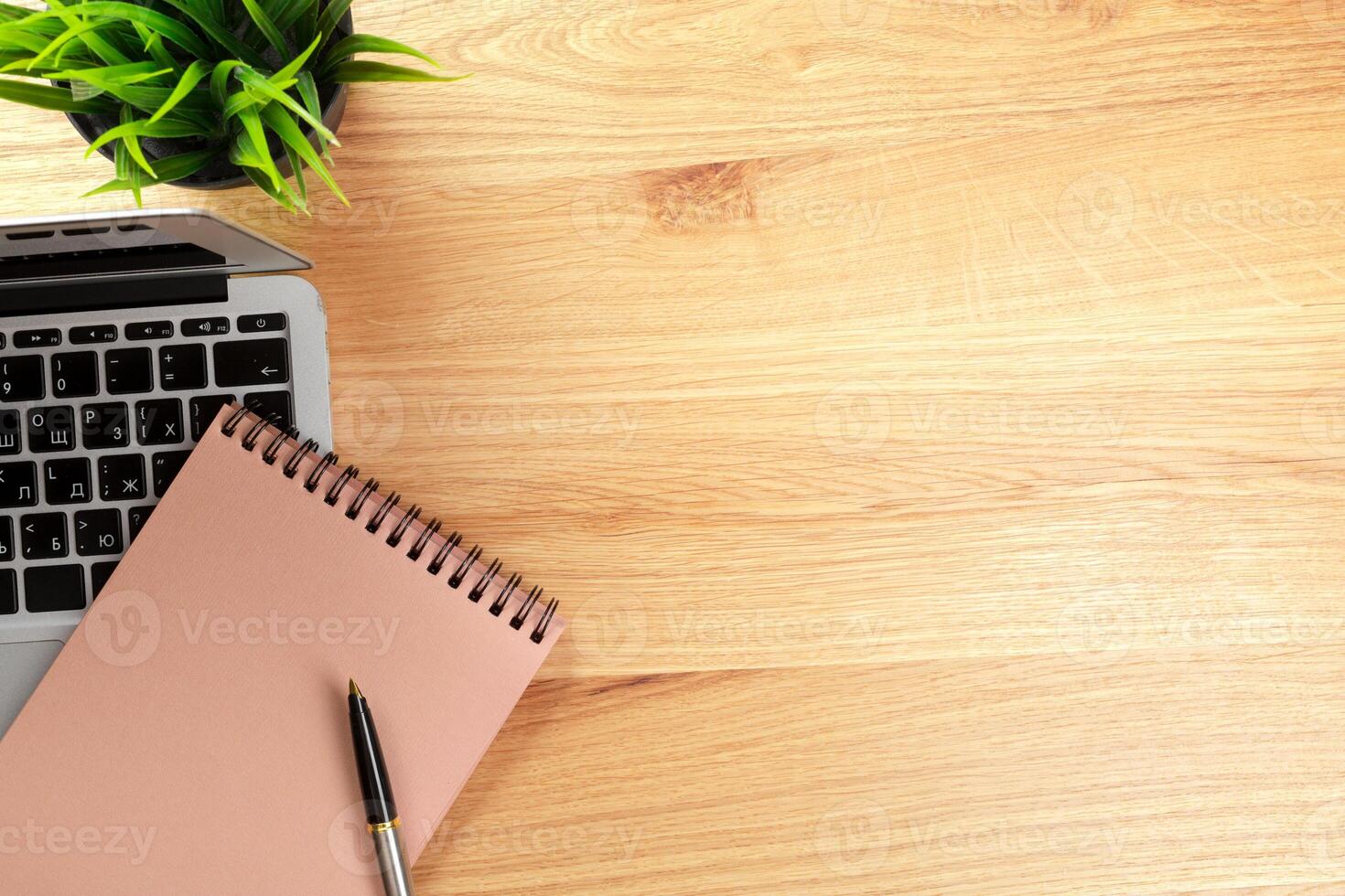 Notepad and laptop on wooden table photo