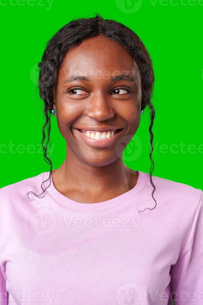 Young woman smiling joyfully in a pink shirt against a vibrant green background in a cheerful atmosphere photo