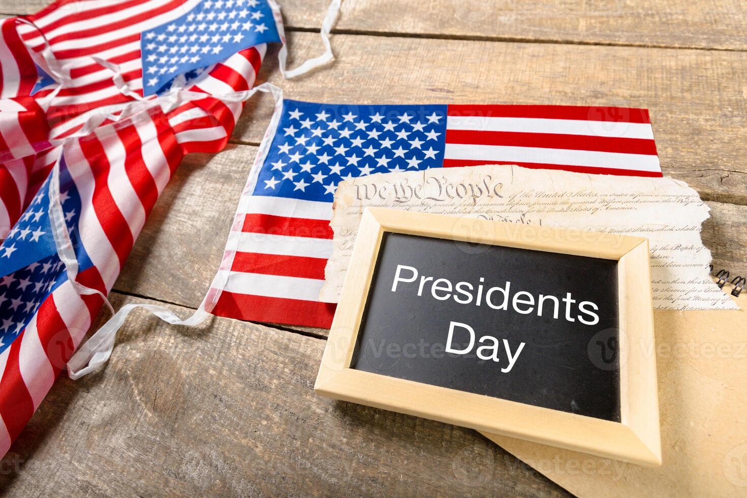 the text happy presidents day written in a chalkboard and a flag of the United States photo