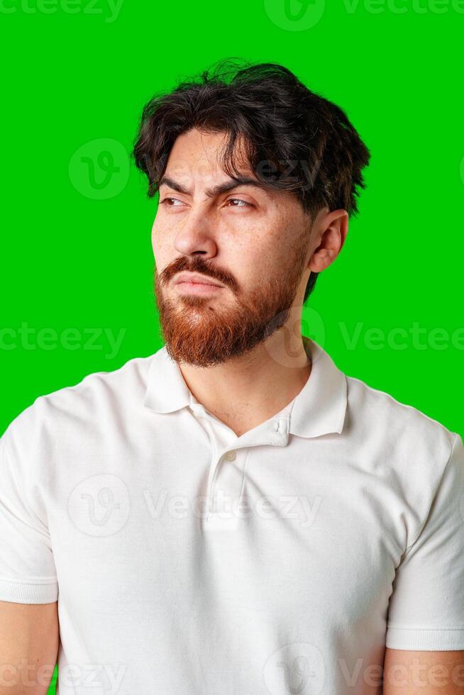 A man with a serious expression stands with crossed arms against a vibrant green background photo