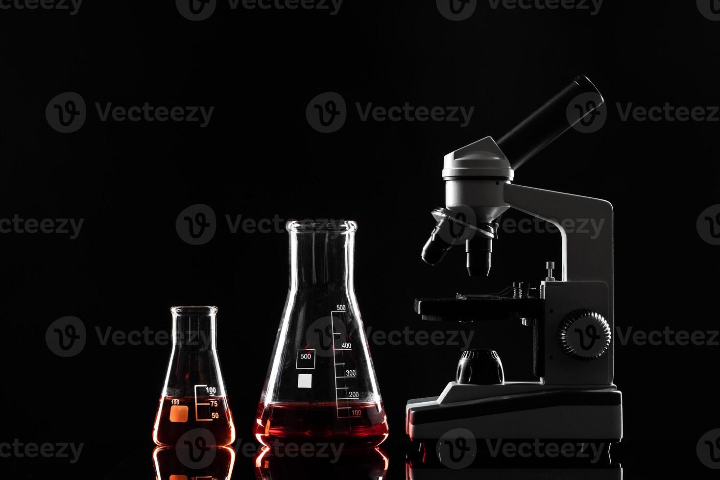 laboratory microscope on table in the dark photo